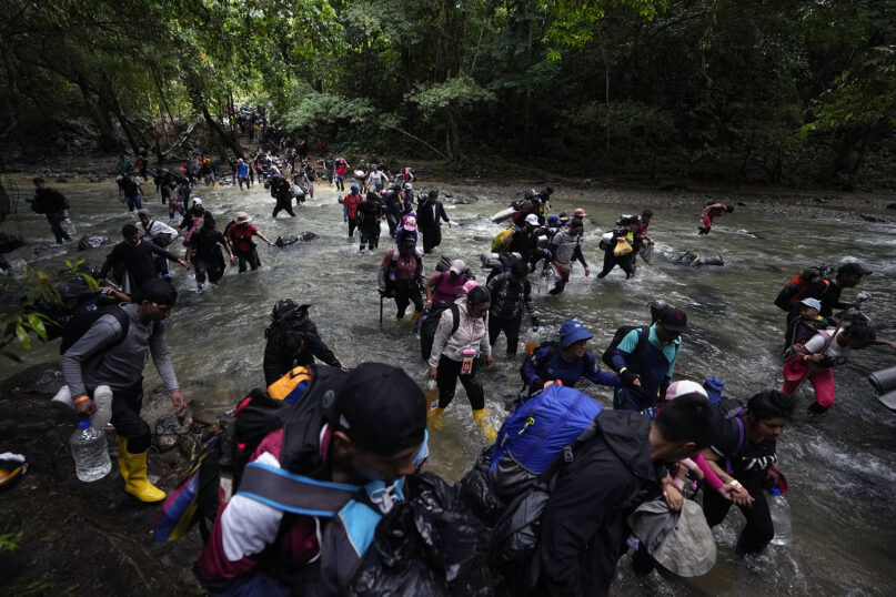 FILE - Migrants, mostly Venezuelans, cross a river during their journey through the Darien Gap from Colombia into Panama, hoping to reach the U.S., Oct. 15, 2022. (AP Photo/Fernando Vergara, File)